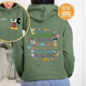May include: Green hooded sweatshirt with a Mickey Mouse design on the front and a Disney-themed classroom quote on the back. The quote reads "Welcome to our classroom where the magic never stops and the adventure never ends!"