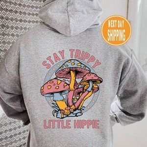 May include: Gray hooded sweatshirt with a graphic of colorful mushrooms and the text "Stay Trippy Little Hippie".