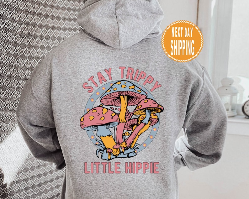 May include: Gray hooded sweatshirt with a graphic of colorful mushrooms and the text "Stay Trippy Little Hippie".