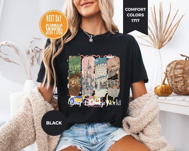 May include: Black t-shirt with a colorful graphic featuring various landmarks and the words "Walt Disney World." The shirt has a round neck and short sleeves. The words "Next Day Shipping" are in a circle on the top left.