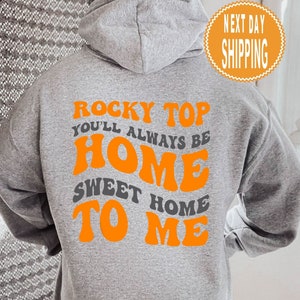 May include: Grey hooded sweatshirt with the text "Rocky Top You'll Always Be Home Sweet Home To Me" in orange letters.