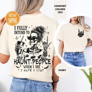 K&ouml;nnte beinhalten: Cremefarbenes T-Shirt mit einem schwarzen Skelett-Motiv, das eine Sonnenbrille tr&auml;gt und einen Kaffeebecher h&auml;lt. Der Text lautet: "I FULLY INTEND TO HAUNT PEOPLE WHEN I DIE I HAVE A LIST." Auf der Vorderseite befindet sich eine Skelett-Hand-Grafik.