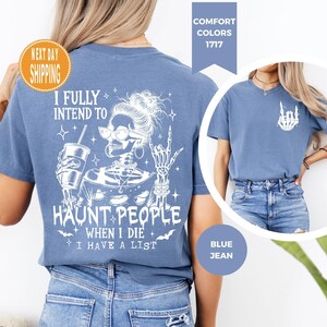 K&ouml;nnte beinhalten: Blaues Jeans-T-Shirt mit einem wei&szlig;en Grafikdesign eines Skeletts mit Sonnenbrille, das ein Getr&auml;nk h&auml;lt und eine Rock-Geste macht. Der Text lautet: "I FULLY INTEND TO HAUNT PEOPLE WHEN I DIE I HAVE A LIST."