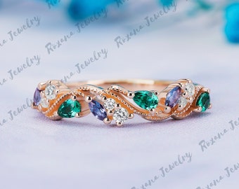 Pode incluir: Uma delicada banda de ouro rosa com um design floral com pedras preciosas verde esmeralda, ametista e redonda branca.