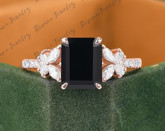 Könnte beinhalten: Ein Verlobungsring aus Roségold mit einem schwarzen Smaragdschliff-Edelstein und einem floralen Design mit pavé-besetzten Diamanten.