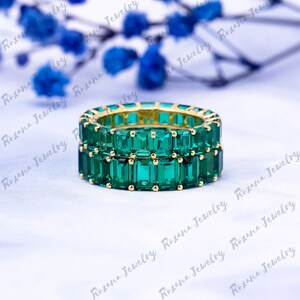 May include: A double band emerald green eternity ring with square cut stones set in yellow gold.