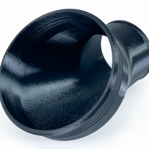 May include: A black 3D printed plastic funnel with a wide opening and a narrower outlet.