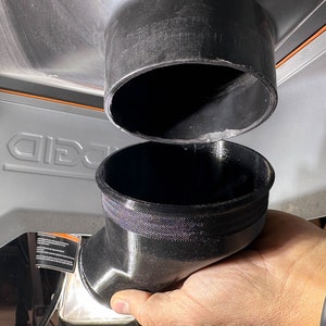 May include: Two black plastic dust collection adapters. The top adapter is a straight pipe, and the bottom adapter is a 90-degree elbow.