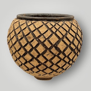 May include: A handcrafted, round ceramic pot with a textured diamond pattern carved into its surface. The pot features a light brown color with dark brown accents in the carved grooves and a dark rim.
