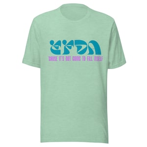 May include: A pale green t-shirt featuring a teal graphic and the text "'CAUSE IT'S NOT GOING TO FILL ITSELF" in purple. The shirt has a crew neck and short sleeves.