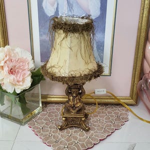 Lámpara de mesa vintage con diseño de mono árabe real bajo una palmera. Color latón.