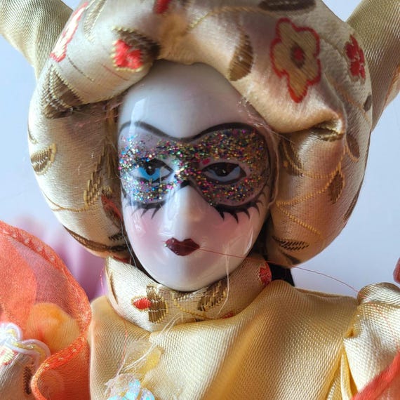 ヴィンテージのベネチアンカーニバル磁器人形。金色の服を着ており
