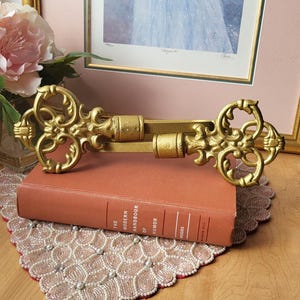 Alzapaños antiguos para cortinas, estilo vintage, con corona de flores doradas en bronce. Juego de 2.