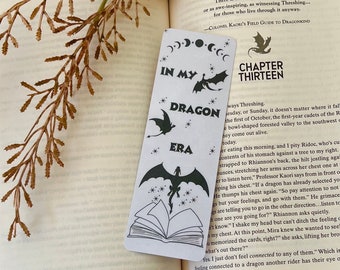 May include: A black and white bookmark with a dragon design and the text "In My Dragon Era" and "Chapter Thirteen".