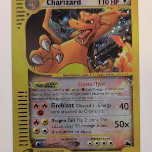 May include: A Charizard Pokémon card, featuring an orange dragon illustration. The card has text including "Charizard", "110 HP", and attack details. The card is from 2003 and has a yellow border.