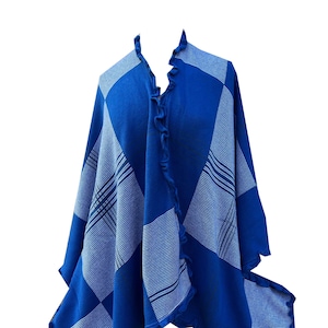 May include: A blue and white plaid shawl with a ruffled edge. The shawl is made of a soft, knitted fabric.