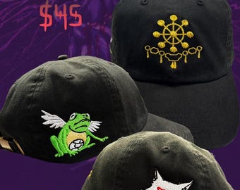 May include: Black and olive green Shikigami Cap baseball caps with embroidered designs. One cap features a gold emblem, another a green frog with wings, and the third a white wolf head with a red triangle. The text "Shikigami Cap" is displayed.