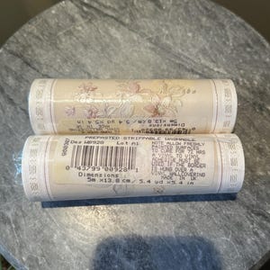 May include: Two rolls of pre-pasted, strippable wallpaper. The wallpaper is cream-colored with a floral pattern in shades of pink and beige. Each roll is 5 meters long and 13.8 cm wide (5.4 inches x 5.4 yards).
