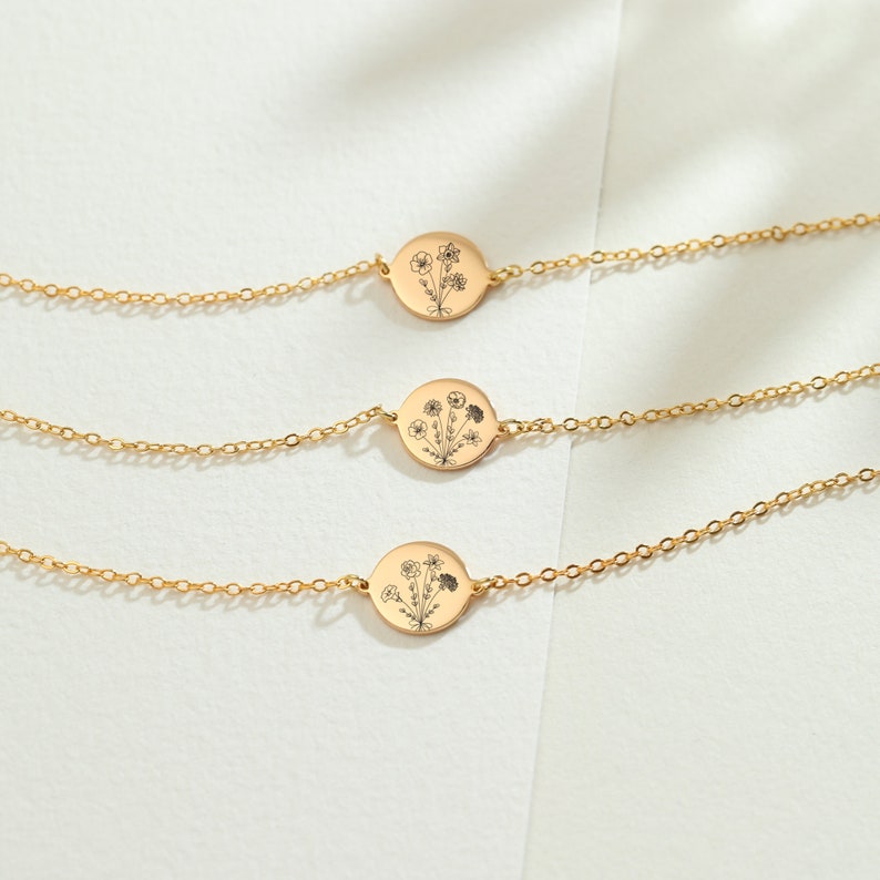 May include: Three gold chain bracelets with a delicate floral design on each pendant.