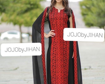 May include: A woman wearing a long black dress with red embroidery and a black sheer overlay. The dress has a V-neck and short sleeves. The text "JOJObyJIHAN" is visible on the dress.