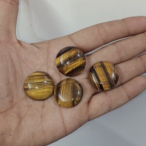 May include: Four round, polished tiger's eye stones with a golden brown and black color pattern.