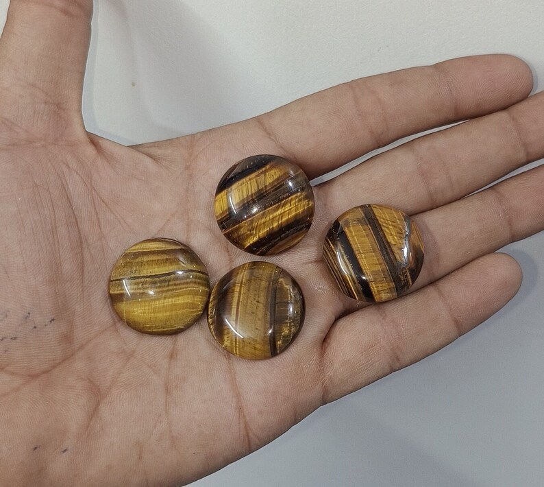 May include: Four round, polished tiger's eye stones with a golden brown and black color pattern.