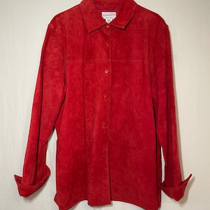 May include: A red suede button-up shirt with long sleeves and a collared neckline. The shirt has a label that reads "Pendleton".