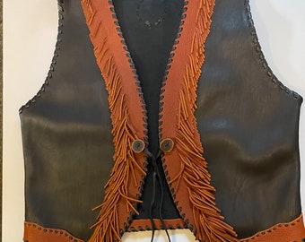May include: A black leather vest with brown fringe trim and a tie closure. The vest has a label that reads "Rolling Thunder".