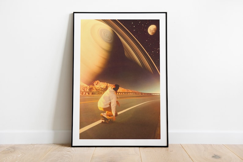May include: A person in a white jacket and jeans rides a skateboard down a road with a large planet and rings in the background.