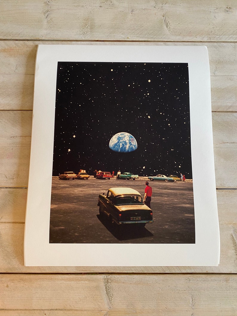 May include: A vintage car parked in a deserted lot with a view of Earth in the night sky. The car is black with a white roof and a license plate that reads "52 1346". A person in a red shirt stands next to the car.
