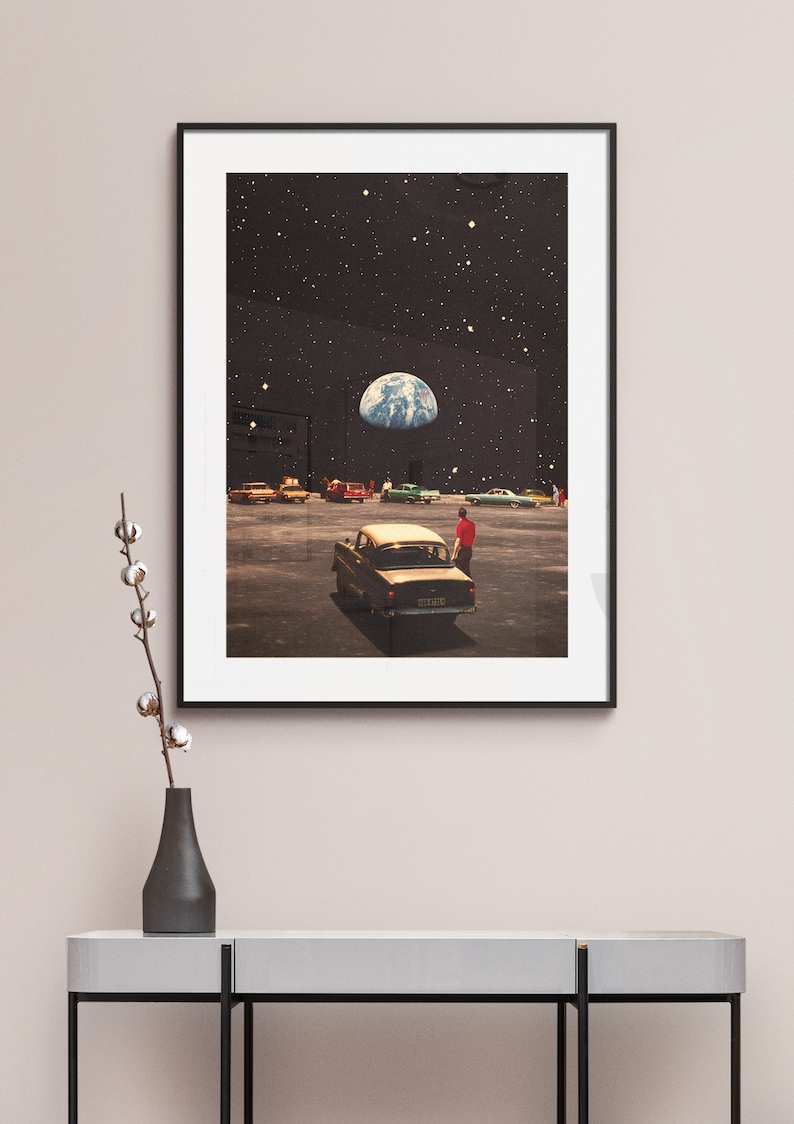 May include: A framed print of a surrealist collage depicting a car parked in a drive-in theater with the Earth visible in the night sky above.