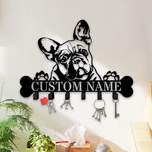 May include: Black metal key holder shaped like a French Bulldog with a bone and paw prints. The holder has five hooks and says "CUSTOM NAME" on the bone.
