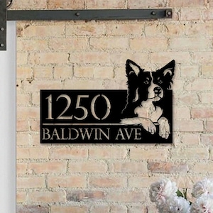May include: Black metal house number sign with a border collie dog silhouette peeking over the top. The sign reads "1250 Baldwin Ave".