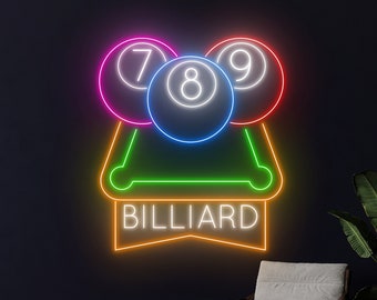 May include: Neon sign with a green billiard table and three billiard balls in a triangle formation. The balls are numbered 7, 8, and 9. The sign also has the word "BILLIARD" in a banner below the table.
