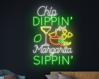 May include: Neon sign with the text "Chip Dippin' And Margarita Sippin'" in green and white. The sign features a margarita glass, a bowl of salsa, a lime, and tortilla chips.