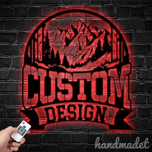 May include: Red illuminated metal sign featuring a mountain scene and the words "CUSTOM DESIGN" in a bold font.