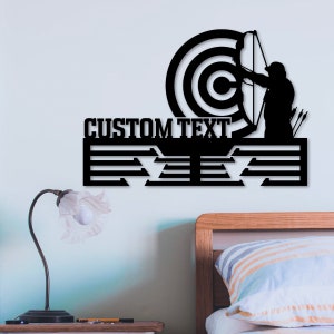 May include: Black metal wall decor featuring an archer aiming at a target with the text "CUSTOM TEXT" above a shelf with five slots.