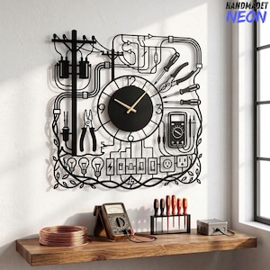 May include: A black metal wall clock featuring an intricate electrical theme with silhouettes of utility poles, tools, light bulbs, and a multimeter. The clock face is circular with gold hands. The text HANDMADET NEON appears in the top right corner.
