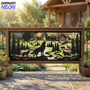 Könnte beinhalten: Eine dekorative Platte aus schwarzem Metall mit einer lasergeschnittenen Silhouette einer Berglandschaft mit Kiefern, einem Vollmond und mehreren Wölfen. Das Design umfasst einen gewundenen Pfad und kleine Tierfiguren in einem rechteckigen Rahmen.