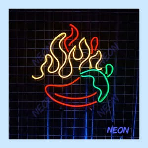 May include: A neon sign featuring a red chili pepper with green accents and yellow flames. The word "NEON" is displayed in blue. The sign is set against a black grid background.