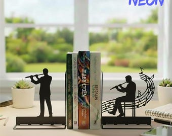 Puede incluir: Soportes para libros de metal negro con siluetas de músicos tocando la flauta. Un sujetalibros muestra a un músico de pie, el otro a un músico sentado con notas musicales. El texto "HANDMADET NEON" está en la esquina superior derecha.