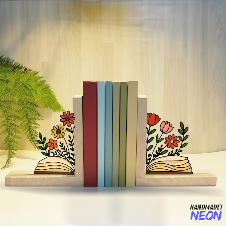 May include: Wooden bookends with laser-cut floral designs. The bookends hold a row of colourful books. The bookends have a light wood finish and feature a floral design with orange, red, and yellow flowers.