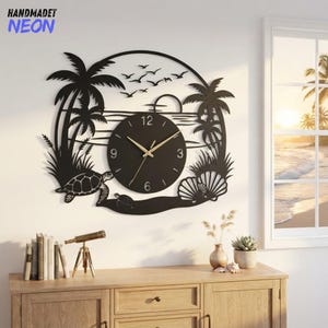 May include: A circular black wall clock featuring a tropical beach scene with palm trees, a sea turtle, seashells, and a flock of birds. The clock face is centered within the design, displaying gold-colored hands and numerals at 3, 6, 9, and 12.