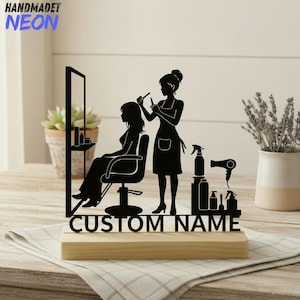 Puede incluir: Una silueta negra de una peluquera cortando el pelo a una clienta, con un espejo y herramientas de salón. La base es de madera, con el texto "CUSTOM NAME" en negro. La esquina superior izquierda tiene el texto "HANDMADET NEON".