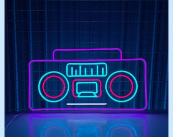 May include: A neon sign shaped like a vintage boombox with pink and blue neon lights. The sign is on a dark blue background with a grid pattern.
