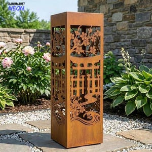 Puede incluir: Una linterna de jardín alta y cuadrada de metal color óxido con diseños cortados con láser de flores de cerezo, una puerta torii y olas estilizadas. El texto HANDMADET NEON es visible en la esquina superior izquierda.
