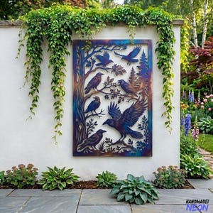 May include: A metal wall art piece featuring a tree and several ravens in flight and perched on branches. The artwork has a blue and purple color scheme and is mounted on a white wall with greenery.