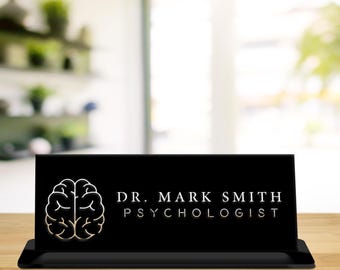 May include: Black desk sign with a white outline of a brain and the text "DR. MARK SMITH PSYCHOLOGIST" in white.