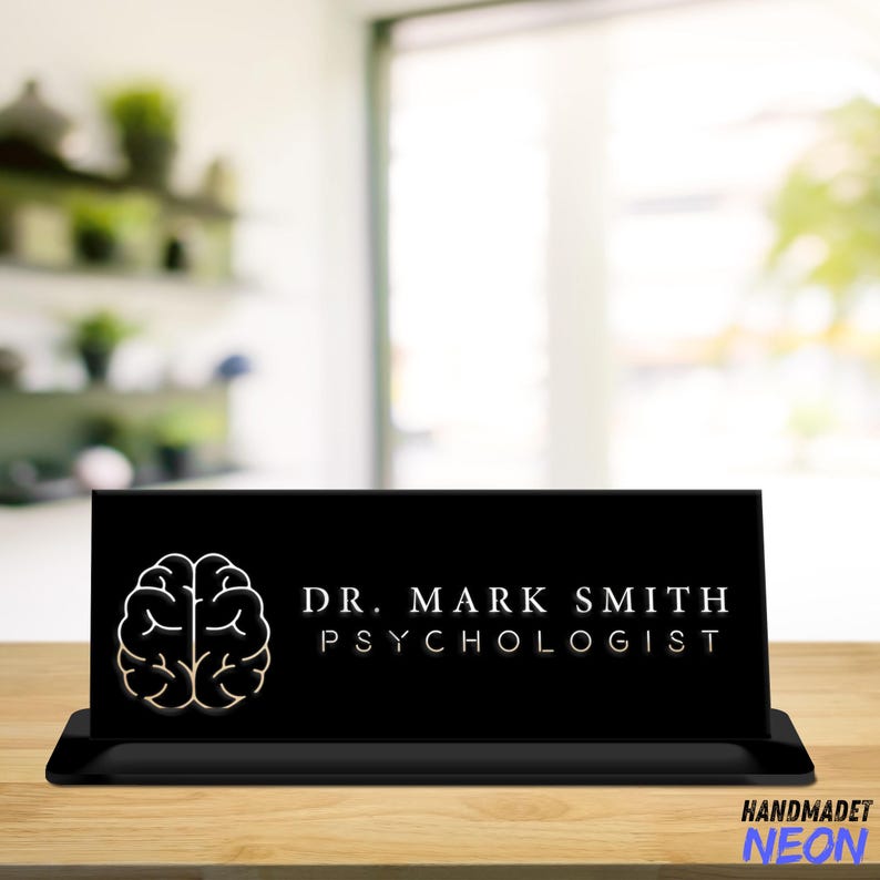 May include: Black desk sign with a white outline of a brain and the text "DR. MARK SMITH PSYCHOLOGIST" in white.