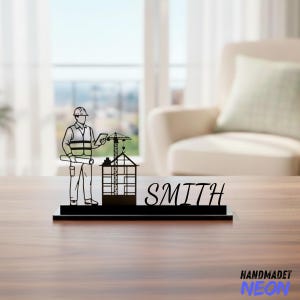 May include: Black desk nameplate with a construction theme. The design features a silhouette of a construction worker, a building under construction, and a crane. The name "SMITH" is displayed. The base has the text "HANDMADET NEON".